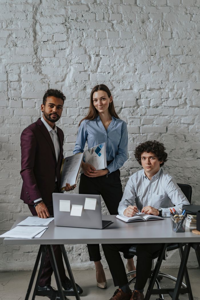 Three colleagues discussing plans in a modern office environment.